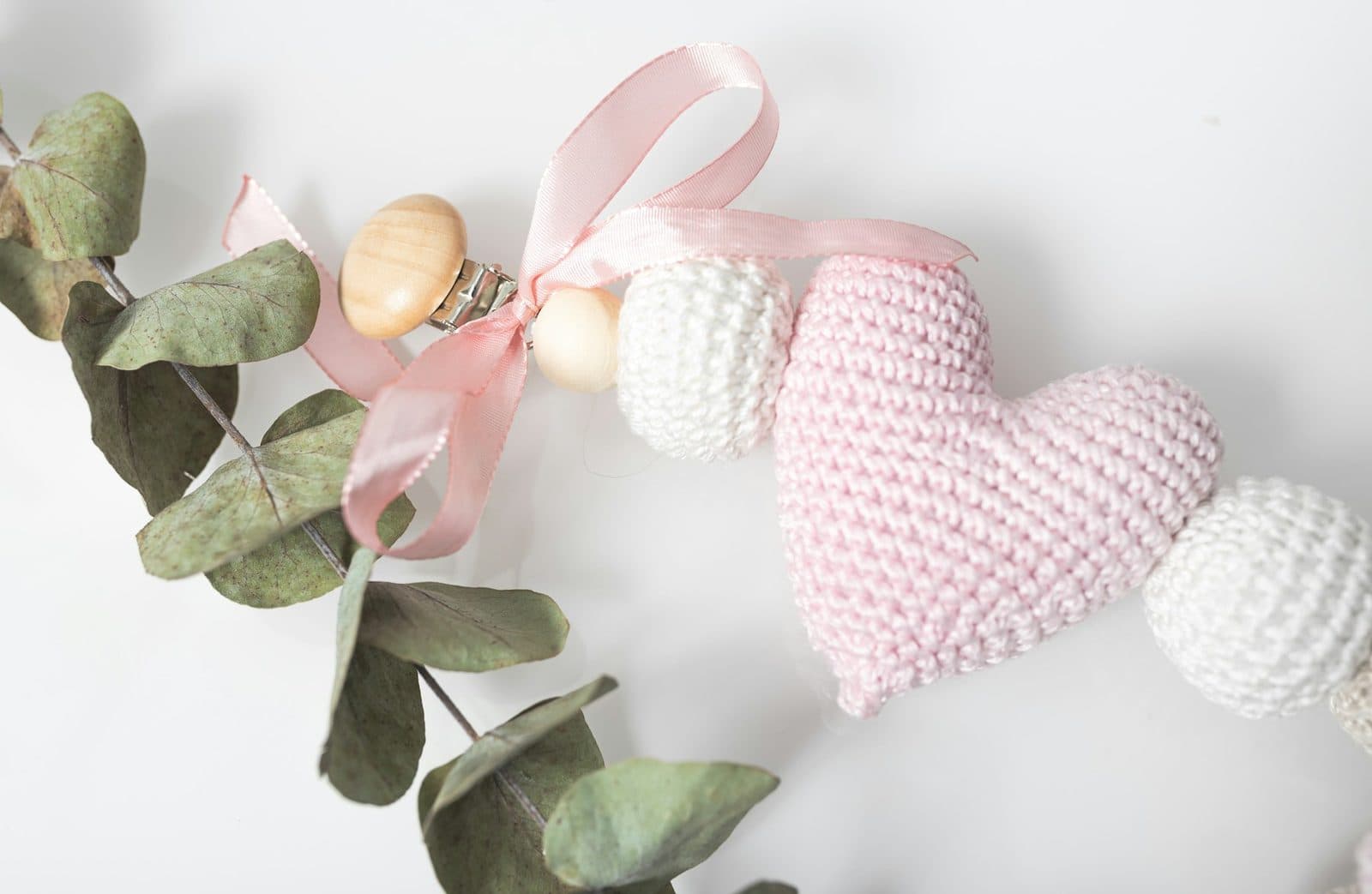 Guirnalda infantil con corazón rosa de ganchillo, cuentas y eucalipto